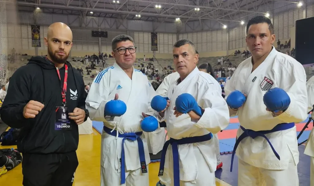 Atletas de karatê de Marília exibindo medalhas de bronze no pódio do Campeonato Paulista de 2026.