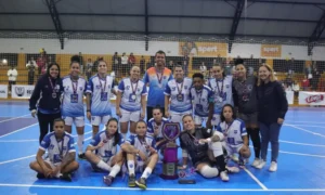 Atletas de futsal feminino de Marília reunidas em quadra recebendo o troféu de segundo lugar.
